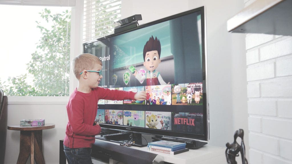 Small child swiping thumbnails on a television